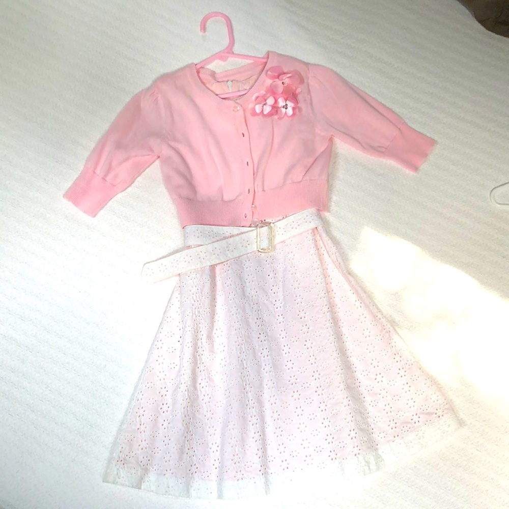 White cotton eyelet dress lined in pink with pink sweater.